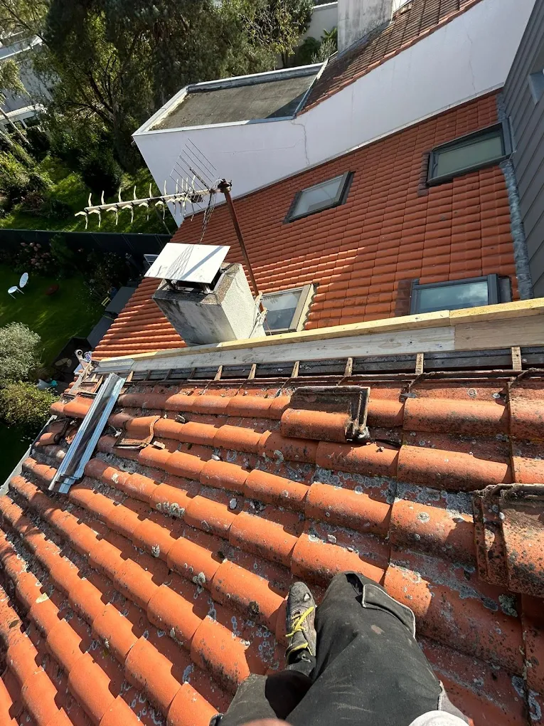 Rive en zinc refaite le long d'un mur sur une toiture en tuiles à Rezé